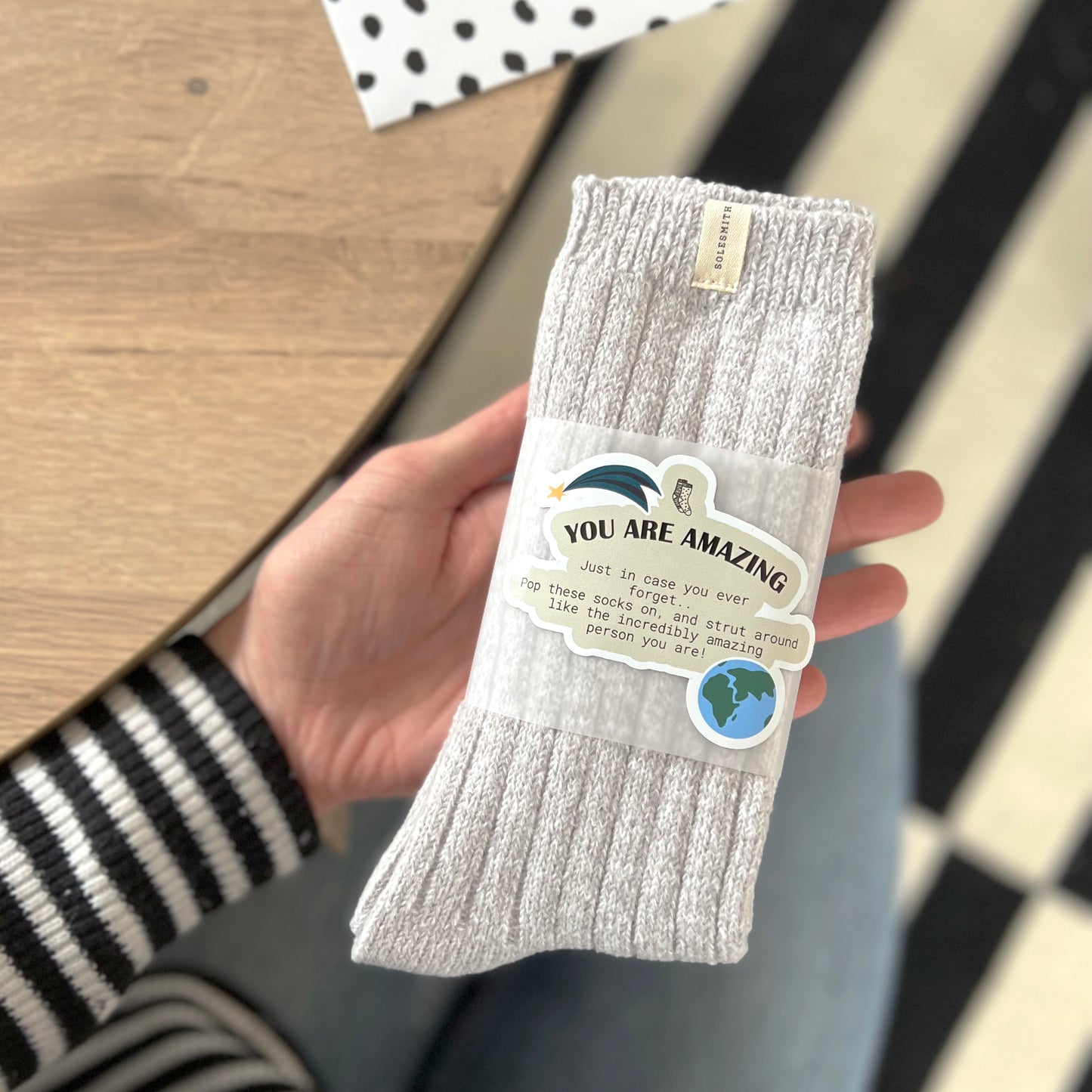 You are amazing packaging around thich ribbed grey snug socks socks being held. 